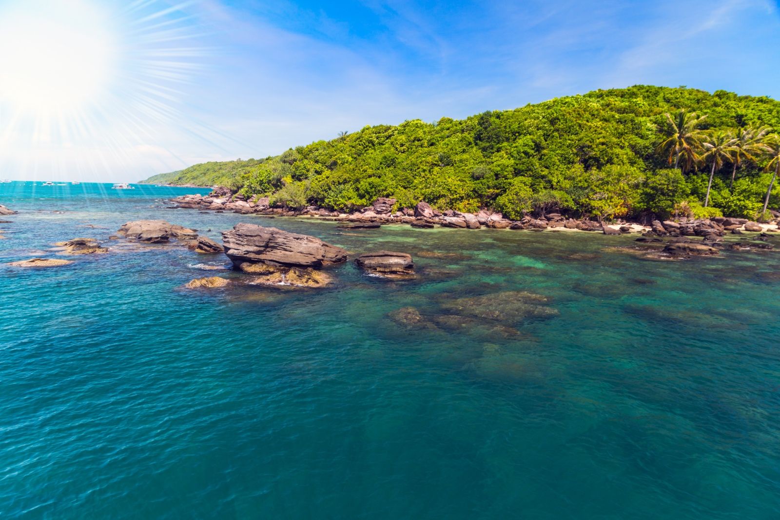 Катамаран стоит на якоре у острова Май Рут во время морского тура Фукуок, гости купаются, катаются на сапбордах и отдыхают в чистой прозрачной воде