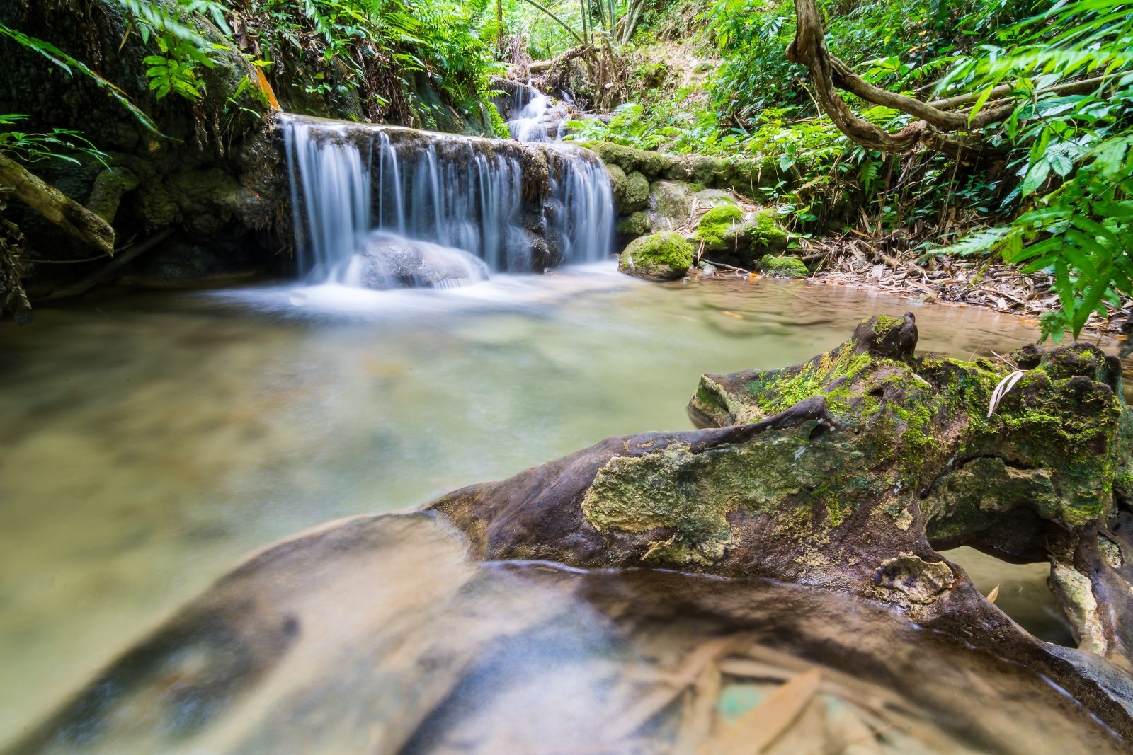 Небольшой водопад Суой Чань на Фукуоке: каскад около трёх метров, естественный бассейн для купания и крупные валуны в тени тропических деревьев — спокойная остановка среди джунглей в экскурсии по острову.